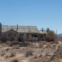 desert landscape with abandoned house in derelict field